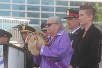 Indigenous Storyteller Theresa Sims, centre, and Windsor Police Acting Chief Jason Bellaire, at the opening ceremonies of the 2022 CanAm Police Fire Games at Riverfront Festival Plaza, July 26, 2022. Photo by Mark Brown/WindsorNewsToday.ca.