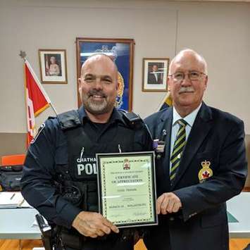 A member of the Royal Canadian Legion, Branch 18, in Wallaceburg presents Constable Todd Trahan with a Certificate of Appreciation. (Photo courtesy of Chatham-Kent police)