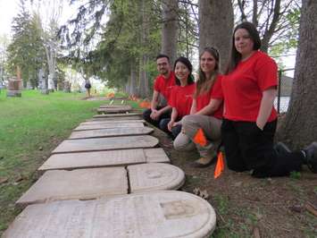 Western University students, Peter Dobrzynski, Sunny Kim, Alyssa Szilagyi, and MacKenzie Brash are uncovering and repairing Confederation-era tombstones at Woodland Cemetery, May 11, 2017. (Photo by Miranda Chant, Blackburn News.)