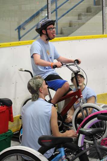 Learning how to ride a bike with the help of volunteers at the iCan Bike Camp in Chatham. July 13, 2016. (Photo by Natalia Vega)