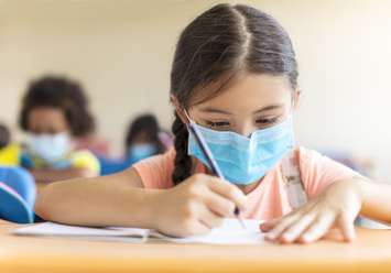 Children wearing face masks in school. (File photo courtesy of © Can Stock Photo / tomwang)