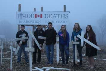 Members of the Eben-Ezer Canadian Reform Church youth group stand at their vandalized Pro LIfe display on Longwoods Rd., December 7, 2015 (Photo by Jake Kislinsky)