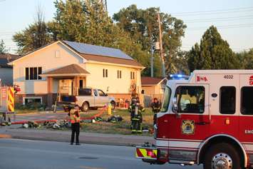 Windsor firefighters take a breather while battling a house fire at Memorial Drive and Vimy Ave, July 9, 2018. Photo by Mark Brown/Blackburn News.
