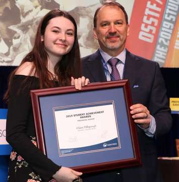 Northern student Claire Tillapaugh accepting a 2019 OSSTF/FEESO Student Achievement Award from President Harvey Bischof. March 2019. (Photo by Ontario Secondary School Teachers’ Federation)