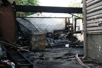 Fire destroyed a garage and damaged the rear of a home on Camelot Cres. July 7, 2015 (BlackburnNews.com photo by Dave Dentinger)