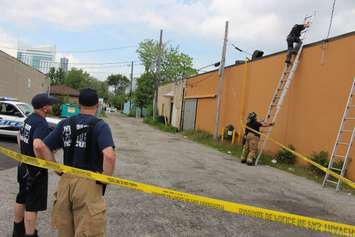 Police officers go on nearby rooftops searching for possible evidence, June 4, 2015. (Photo by Jason Viau)