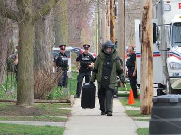 London police explosive disposal unit member, entering 820 Princess Ave. where a suspected man-made bomb was found, April 11, 2017. (Photo by Miranda Chant, Blackburn News.)