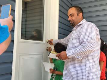 Ezzeideen El Ahmad turns the key to his family's new Habitat For Humanity home - May 30/22 (Blackburn Media photo by Josh Boyce)