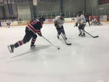 A Walkerton Hawk tries to slip by two Wingham Ironmen in Game 1 of the 2014-2015 Western Jr. C Final.  Photo by Marty Thompson.