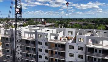 The last wall panel being installed at 1100 Afton. Image submitted by Growth and Performance Vice President Lauren Pomerleau.