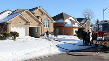 Homeowners return to the scene of a blaze in the 4200-block of Barton Cres., February 23, 2015. (Photo by Mike Vlasveld)