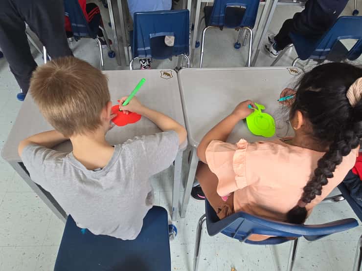 Lansdowne Public School students draw on their paper apples at the Great Big Crunch - Mar. 26/26 (Blackburn Media Photo by Josh Boyce)