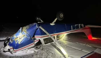 A blue and white plane turned upside down after it crashed