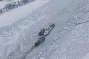 The Canadian Coast Guard Ships Griffon and Samuel Risley work to get a tug and barge through thick ice on the St. Clair River. Photo courtesy United States Coast Guard.
