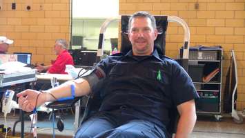 Constable Doug Cowell of the Chatham-Kent Police Service donates blood as part of the Uniforms Unite To Save Lives Campaign. (Photo by Jake Kislinsky)