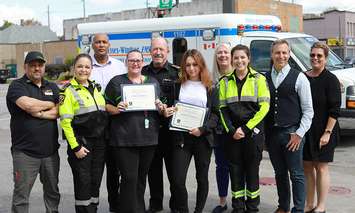 A commendation is presented on September 18, 2023, to employees and representatives at the 7-Eleven on Wyandotte Street East in Windsor. From left, Store Leader Nas Krefel; Essex-Windsor EMS District Chief Sarah Bezaire; 7-Eleven Canada Senior Director Mel Tiruneh; Jamie Tremblay; Essex-Windsor EMS Chief Bruce Krauter; Maryam Jamali; 7-Eleven Area Leader Karen Erickson; Paramedic Danielle Beauchamp; 7-Eleven Canada Vice-President and General Manager Marc Goodman; and 7-Eleven Market Manager Cheryl Magnuson. Submitted photo.