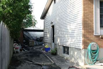 Fire destroyed a garage and damaged the rear of a home on Camelot Cres. July 7, 2015 (BlackburnNews.com photo by Dave Dentinger)