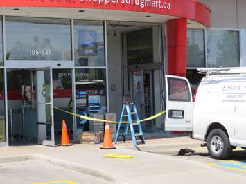 Crews work to repair the front entrance of the Shoppers Drug Mart at 645 Commissioners Rd. E after a car crashed through the glass doors, June 12, 2018. (Photo by Miranda Chant, Blackburn News)