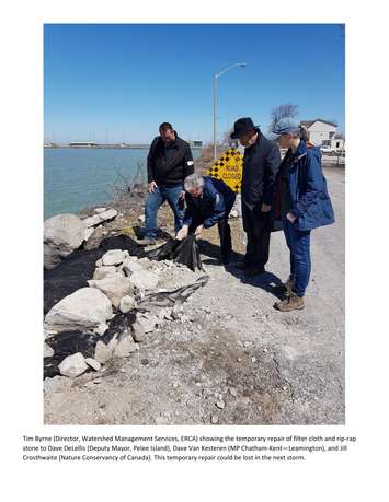 Tim Byrne of ERCA, second from left, shows the temporary repair of filter cloth and rip-rap stone to Pelee Island deputy mayor Dave DeLellis, MP Dave Van Kesteren, in hat, and Jill Crosthwaite of the Natural Conservancy of Canada on April 20, 2018. Photo courtesy of Adam Roffel.

