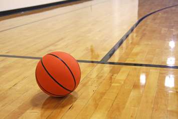 A basketball on a hardwood court. © Can Stock Photo / BLewis