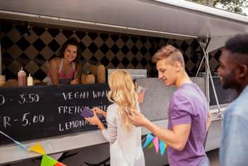 Happy Customers Queue At Food Truck @CanStock photo by dolgachov