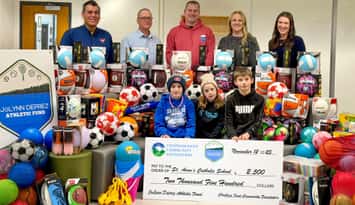 Cheque presentation (Back row, L-R): Ahmad Ghayeni, Canadian Tire Store Owner; Chris Pegg, Executive Director, CK Community Foundation; Chris Deprez, Founder, JoLynn Deprez Athletic Fund; Jillian Watterworth, Teacher; and Tiffany Clarke, Principal (Front row L-R): St. Anne students Bryden Watterworth (Grade 4); Kadence Watterworth (Grade 1); and Cole Cooper (Grade 7) (Image courtesy of the St. Clair Catholic District School Board)