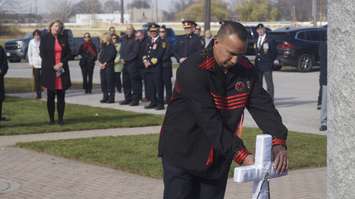 Brian Bois, representing First Nation Veterans, places a Poppy on a white cross during Aamjiwnaang First Nation's annual Remembrance Day ceremony. 10 November 2022. (Photo by SarniaNewsToday.ca)