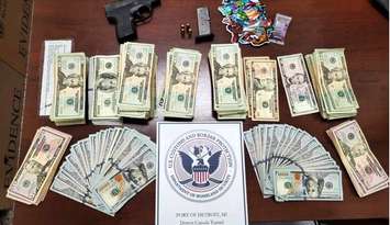 An assortment of US cash is displayed with a weapon and cannabis products at the Windsor-Detroit Tunnel in Detroit. Photo courtesy DFO Marty C. Raybon/X.