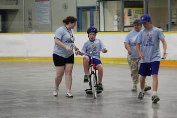 Learning how to ride a bike with the help of volunteers at the iCan Bike Camp in Chatham. July 13, 2016. (Photo by Natalia Vega)