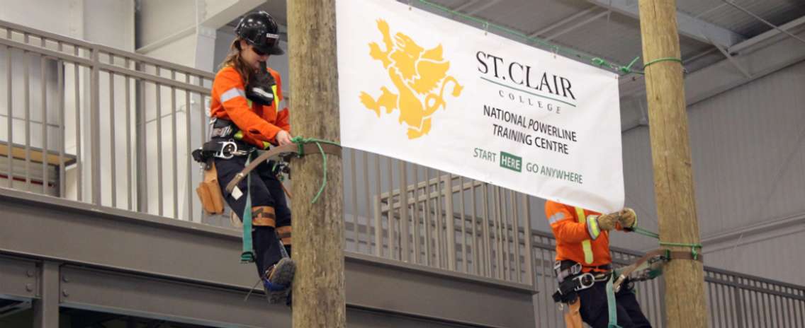 Students of the powerline program at St. Clair College Thames Campus climb the poles to release banners at the grand opening of the Powerline Training Centre. October 19, 2018. (Photo by Greg Higgins)