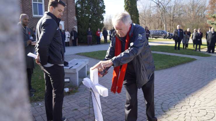 Mayor Mike Bradley putting a poppy on a cross at the Aamjiwnaang Remembrance Day ceremony (Photo by: Lindsay Newman/ Blackburn Media)