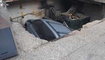 A vehicle inside a sinkhole in downtown Windsor. September 19, 2023. Photo via @drewdilkens on X.  
