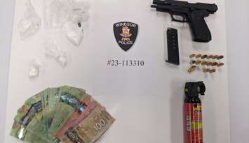 An assortment of cash, weapons, and suspected drugs are displayed on September 29, 2023. Photo provided by Windsor Police.