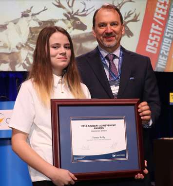 LCCVI student Emma Kelly accepting a 2019 OSSTF/FEESO Student Achievement Award from President Harvey Bischof. March 2019. (Photo by Ontario Secondary School Teachers’ Federation)
