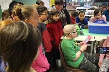 Huntre Allard reads a card as he is surrounded by Grade 4 classmates at Our Lady of Perpetual Help School in Windsor, February 11, 2019. Photo by Mark Brown/Blackburn News.