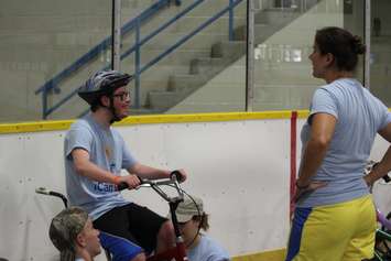 Learning how to ride a bike with the help of volunteers at the iCan Bike Camp in Chatham. July 13, 2016. (Photo by Natalia Vega)