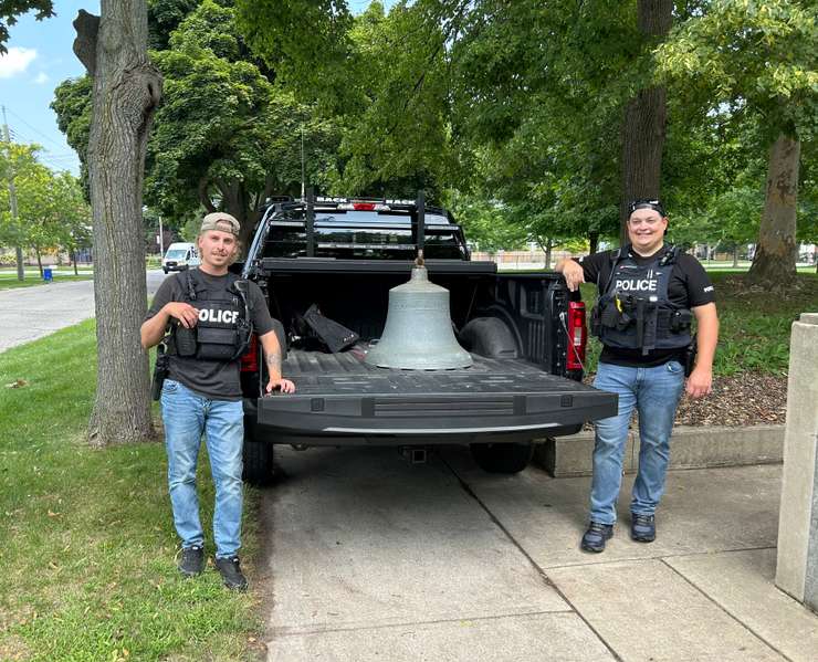 Two members of the Sarnia Police Service with the recovered George Street School Bell, July 2024 (Photo by Lindsay Newman/ Blackburn Media)