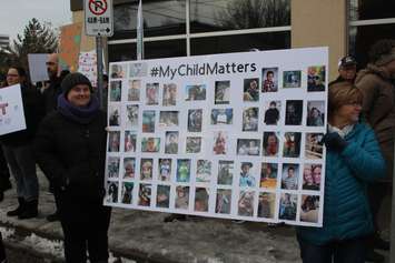 Demonstrators hold up signs at a rally outside the Ministry of Children, Community and Social Services field office in Windsor, February 14, 2019. Photo by Mark Brown/Blackburn News.
