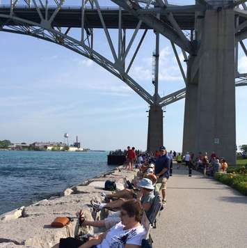 Crowds gather below the bridge to watch the start of the Mackinac sailboat race. Photo sent by Blackburn Radio app.