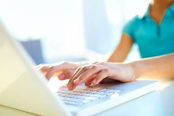 Close-up shot of a female learner typing on a laptop keyboard. © Can Stock Photo / pressmaster