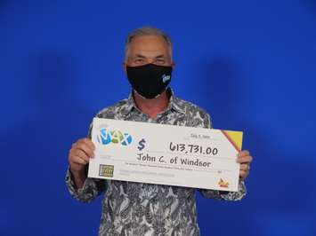 John Chisholm of Windsor displays his winning Lotto Max cheque at the OLG Prize Centre in Toronto, July 7, 2021. Photo provided by OLG.
