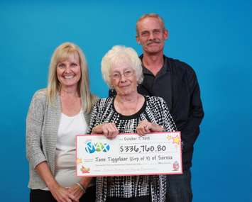 Jane Tiggelaar, Terence Tiggelaar and Laurie Fach hold up their LOTTO MAX lottery winnings. (Photo courtesy of the OLG)