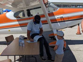 Chris Hadfield signs four-year-old Andrew's book. August 14, 2021. (Photo by  Natalia Vega)