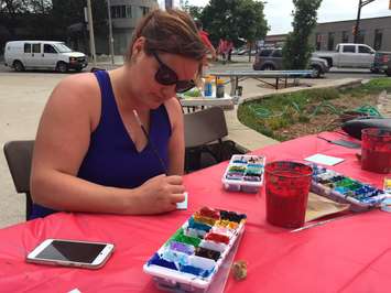 Volunteer Miranda Pretty paints a tile to be included in Sarnia's Canada 150 Mural Mosaic. June 13, 2017 (Photo by Melanie Irwin)