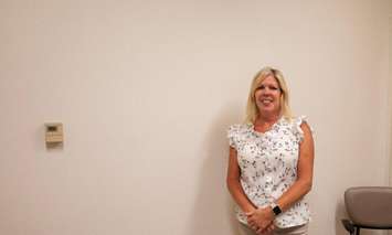 Tara Greenway, Sexual Assault/Domestic Violence Team Lead and Clinical Resource Nurse, standing in front of the mural wall (Image courtesy of Chatham-Kent Health Alliance)