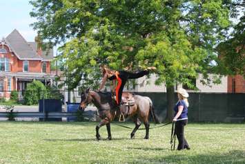 Vollans shows off her skills with her favorite trick as she hangs onto her horse using only one foot. June 12, 2018 (Photo by Greg Higgins)