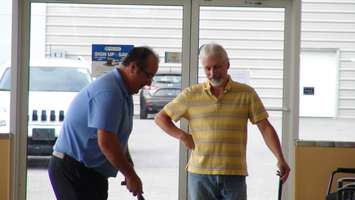 Scott Pelltier (right) watches Chatham Chrysler Financial Services Manager John Torrieri putt (Photo by Jake Kislinsky)