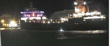 A tug boat pulls the Wilfred Sykes bulk freighter after the large vessel lost its steering near the Blue Water Bridge. 25 November 2021. (Photo by Blue Water Convention Centre in Port Huron)