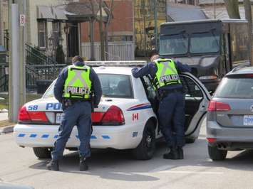 London police officers speak to a man in the back of their cruiser in the downtown. (Photo by Miranda Chant, Blackburn Media)