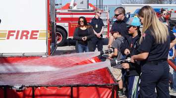 Students gets a feel for how powerful a fire hose is. Photo by Jake Jeffrey. May 6, 2016 (blackburnnews.com)